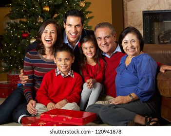 Multi Generation Family In Front Of Christmas Tree