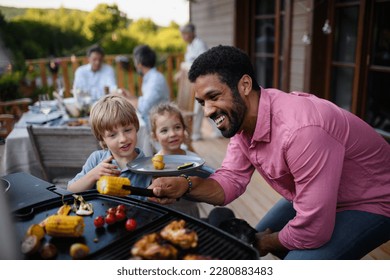 Multi generation family having bbq party outside in the backyard on patio. - Shutterstock ID 2280883483