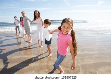 Multi Generation Family Having Fun On Beach Holiday