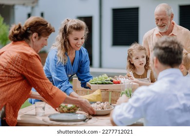 Multi generation family having outdoor garden party. - Powered by Shutterstock