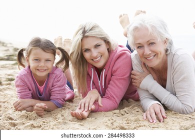 Multi Generation Family Lying On Beach Together