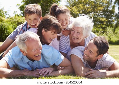 Multi Generation Family Piled Up In Garden Together - Powered by Shutterstock