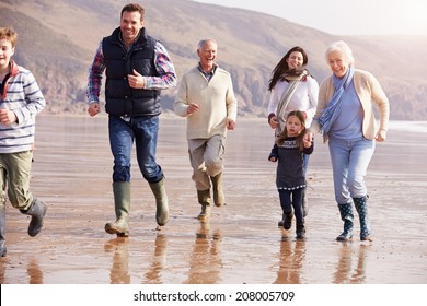 Multi Generation Family Running On Winter Beach