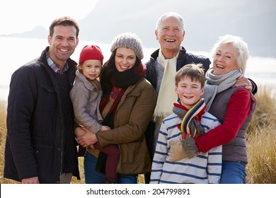 Multi Generation Family In Sand Dunes On Winter Beach