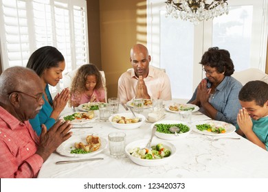 Multi Generation Family Saying Grace Before Meal At Home - Powered by Shutterstock