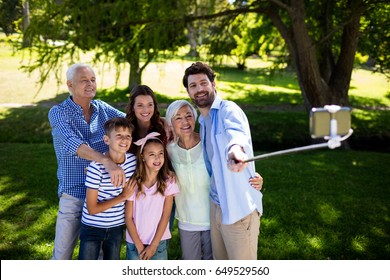 Multi Generation Family Taking A Selfie With Selfie Stick In Park