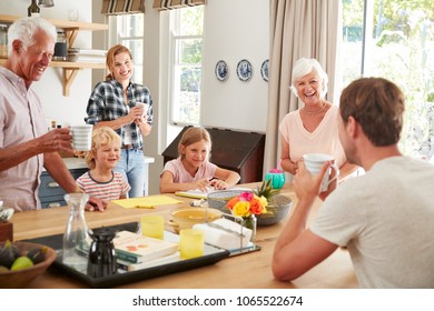 Multi Generation Family Talking At Home In Their Kitchen