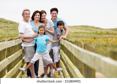 Multi Generation Family Walking Along Wooden Bridge