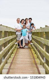 Multi Generation Family Walking Along Wooden Bridge