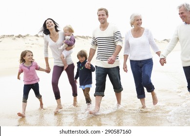 Multi Generation Family Walking Along Beach Together