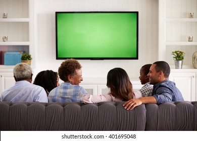 Multi Generation Family Watching TV And Laughing, Back View