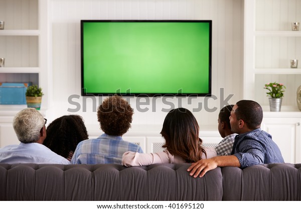 Multi\
generation family watching TV at home, back\
view