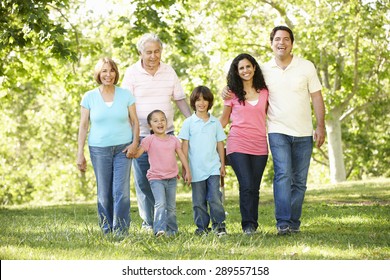 Multi Generation Hispanic Family Walking In Park