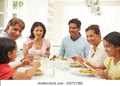 Multi Generation Indian Family Eating Meal At Home