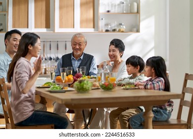 multi generational asian family chatting while having meal together at home - Powered by Shutterstock