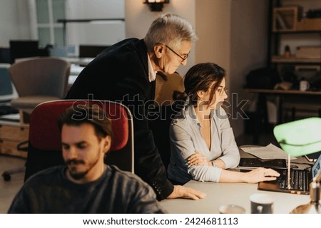 Multi generational colleagues in an office working together on projects, focused on productivity and success.