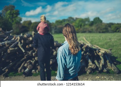 A Multi Generational Family Is Looking At Some Logs In The Forest