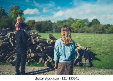 A Multi Generational Family Is Looking At Some Logs In The Forest