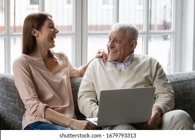 Multi generational family spend time together, cheerful grown up granddaughter and grandfather resting on couch laughing talking using laptop, social worker caregiver and mature patient care concept - Powered by Shutterstock