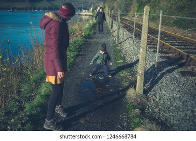 A Multi Generational Family With A Toddler And Grandfather Are Walking By The Railway Tracks