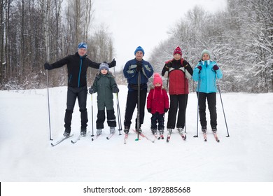 Multi Generational Family With Two Kids Cross-country Skiing In The Winter Forest In The Snow