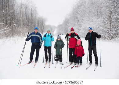 Multi Generational Family With Two Kids Cross-country Skiing In The Winter Forest In The Snow