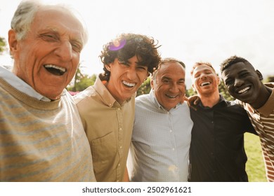 Multi generational men smiling in front of camera - Male multiracial group having fun togheter outdoor - Focus on left boy face - Powered by Shutterstock