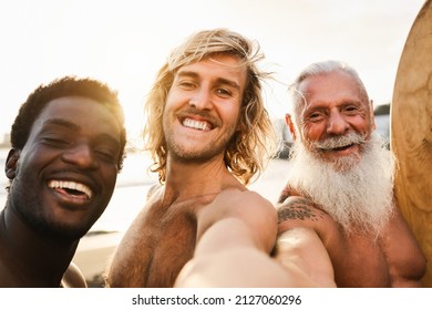 Multi Generational Surfer Friends Having Fun Doing Selfie On The Beach After Surf Session - Focus On Center Guy Face