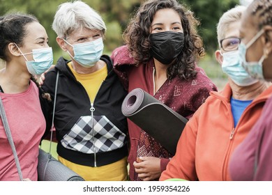 Multi Generational Women Having Fun Before Yoga Class Wearing Safety Masks During Coronavirus Outbreak At Park Outdoor - Main Focus On Center Girl Face