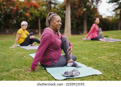 Multi generational women having fun doing yoga exercise at city park together - Focus on african senior woman - Shutterstock ID 2233913195