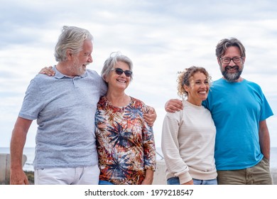 Multi Generations Family Walking Together In Outdoor Smiling Carefree. Parents, Son And Daughter-in-law