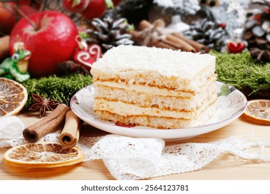 Multi layer cake with vanilla, coconut and white chocolate among Christmas decorations.