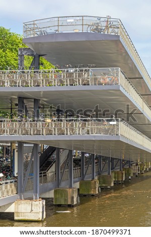 Image, Stock Photo A row of bicycles, behind them greenhouses, behind them the typical narrow buildings of downtown Amsterdam