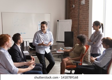 Multi racial businesspeople gather at briefing, positive team leader talking to office employees interns or students at corporate training teach explain project strategy discuss business plan concept - Shutterstock ID 1418789168
