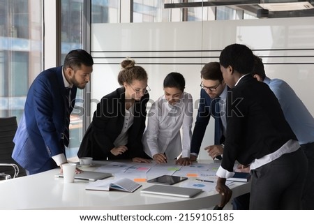 Multi racial company management, staff members cooperate together gather in boardroom at briefing, discuss business ideas, search solution, review sales results engaged in teamwork, brainstorm concept