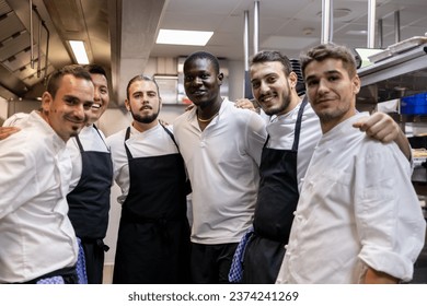 Multi racial cooking team posing for a team photo in the kitchen at work - Powered by Shutterstock