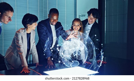 Multi racial group watching hologram of the earth in dark office. Global network. - Powered by Shutterstock