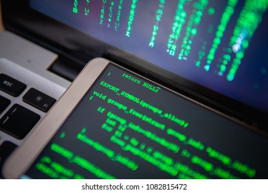 Multi Screen Runing Command. Hacker Working With Multi Computer Device. On The Table Have Personal Computer, Laptop And Mobile. On Screen Showing Binary Code