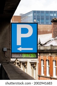 Multi Storey Car Park P Sign Blue With Bright Green Neon Writing Showing Spaces And Arrow. Carpark Spaces Available Empty In England UK. Electric Sign Board.