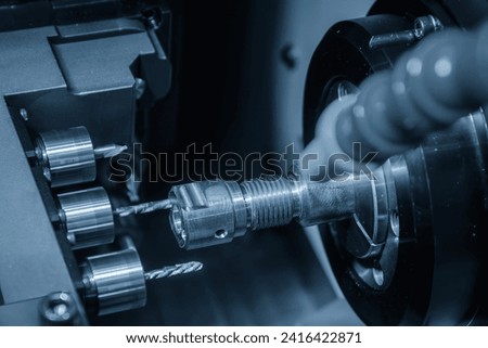 The  multi tasking CNC lathe machine swiss type drilling the brass fitting parts. The hi-technology metal working processing by CNC turning machine .