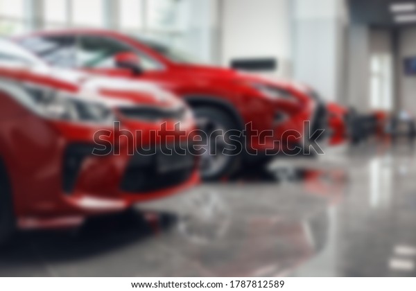 Multi-brand car dealership.\
Blur the background of the car and Showroom at blurred in\
workplace. Blurred dealership store, with the cars and soft\
lightning. New red\
cars