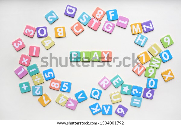Multi-color Alphabet ABC letters and number and\
mathematics sign in square flat papers on white background with\
PLAY at center.