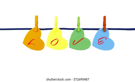 Multi-color love shapes with text L O V E clipped mini multi-color wooden clip on blue rope isolated on white background