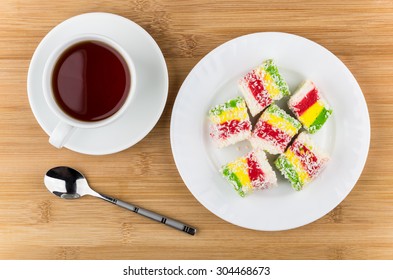 Multicolor Turkish Delight In Glass Plate And Cup Of Tea On Wooden Table, Top View