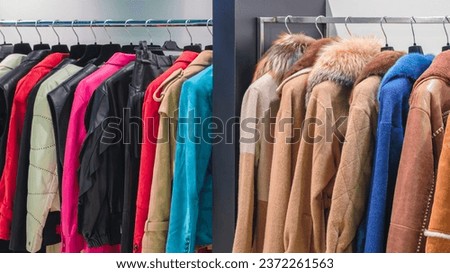 Multicolor women's coats, fur coats and jackets on hangers in the store