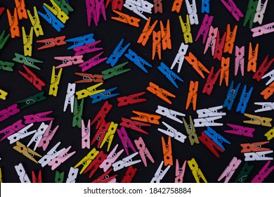 multicolor wooden pins on black background, colorful banner for text