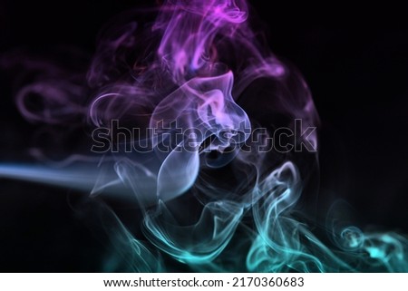 Multicolored abstract smoke for relaxation, close up black background, beautiful swirled clouds of smoke. Pink, purple and turquoise gradient colors of dense smoke, multi colour smoke curls