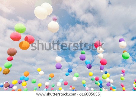 Multicolored balloons hanging on a string against the blue sky