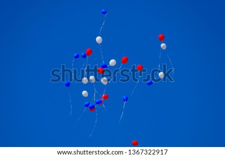 Multicolored balls, filled with helium, fly in the blue sky.