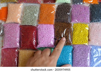 Multicolored beads close-up in bulk and packed in a bag or jar, for the work of needlewomen